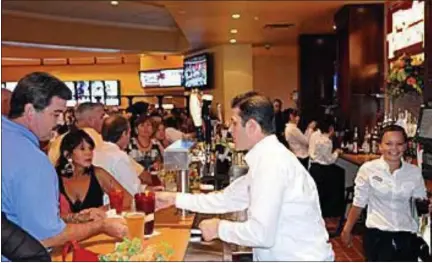  ?? MEDIANEWS GROUP FILE PHOTO ?? The Movie Tavern chain of theaters has been sold — including three in the tri-county area. This file photo shows people at the bar and dining area at the Movie Tavern at Providence Town Center in July 2011, getting something to eat and drink before their movie.