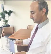  ?? JIM SMITH — DAILY DEMOCRAT ?? Inder Wadhwa, chief executive officer of Northern Valley Indian Health, looks over a rendering of a new 20,000-square-foot facility at County Fair Mall.