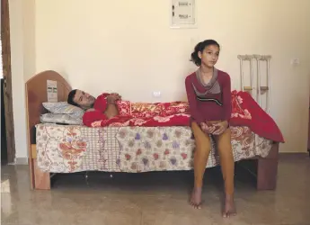  ?? Florian Neuhof for The National ?? Riham Qudaih, 14, and her father Ismael in their family home in Khan Younis. He is recovering from an Israeli bullet wound. She wants to live her life away from Gaza