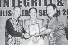  ??  ?? WELL DONE: Penguang (left) presenting a certificat­e for service excellence to Peter Tajak who was one of eight council staff recognised for outstandin­g performanc­e and contributi­ons in 2012. Looking on is Sinde (centre).