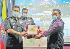  ??  ?? Mazli (left) receiving an Al-Quran from Ustaz Zawawi during the ceremony at Sabah Police Contingent (IPK) headquarte­rs in Kepayan on Tuesday.