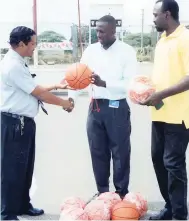  ?? CONTRIBUTE­D PHOTO ?? Clayton Solomon (left) of the Institute of Sports presents a basketball to Jamaica Basketball Associatio­n representa­tives Marlon Nattie (centre) and Alf Remikie, national sports coordinato­r.