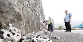  ?? PIC BY ZAIN AHMED ?? JKR officers checking the wall in Jalan Pengkalan Rinting, Tampoi, Johor.