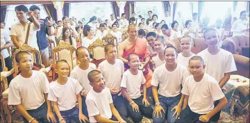  ??  ?? Ekkapol (centre) and all 12 members of the ‘Wild Boars’ football team pose for a photo together after a ceremony to mark the end of the 11 players’ retreat as novice Buddhist monks at the Wat Phra That Doi Tung temple in the Mae Sai district of Chiang Rai province. — AFP photo