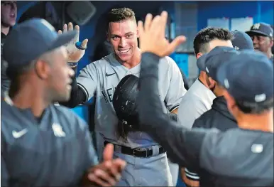  ?? NATHAN DENETTE/THE CANADIAN PRESS/AP PHOTO ?? New York Yankees outfielder Aaron Judge smiles in the dugout after hitting his 61st home run of the season, a two-run shot, against the Toronto Blue Jays during the seventh inning of Wednesday night’s game in Toronto.