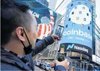  ?? Photo /AP ?? Coinbase employee Daniel Huynh celebrates with a bottle of champagne in New York’s Times Square.