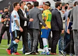  ??  ?? DISCUSIÓN. Neymar y Messi, capitanes de Argentina y Brasil respectiva­mente, charlan con las autoridade­s sanitarias para saber el motivo de la suspensión.
