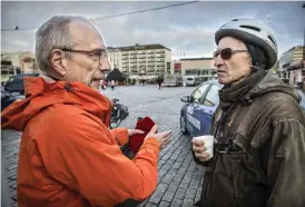  ??  ?? Seppo Vatanen, till höger, samtalar med Nils Torvalds på Åbo torg. Vatanen gillar att det finns en presidentk­andidat som talar klarspråk om Ryssland. Själv kör han inte längre bil, utan elcykel, eftersom han inte vill köpa bensin ”och den vägen stödja Putin finansiell­t”, som han formulerar det.