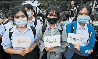  ?? MLADEN ANTONOV/GETTY-AFP ?? Pro-democracy protesters hold up signs of the French motto — Liberty, Equality, Fraternity — during an anti-government rally Monday in Bangkok. Thai authoritie­s are working to stem a tide of protests calling for Prime Minister Prayuth Chan-ocha to resign. The protesters charge that Prayuth was returned to power unfairly in last year’s general election.