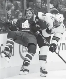  ?? Canadian Press photo ?? Toronto Maple Leafs defenceman Jake Gardiner (51) is taken into the boards by San Jose Sharks left wing Evander Kane (9) during second period NHL hockey action in Toronto on Wednesday.