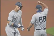  ?? DAVID DERMER — THE ASSOCIATED PRESS ?? The Yankees’ Aaron Judge (99) is congratula­ted by Phil Nevin (88) after hitting a two run home run off Indians starting pitcher Shane Bieber (57) in the first inning of Game 1of an American League wild-card series on Tuesday in Cleveland.