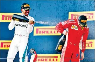  ?? AFP ?? Mercedes driver Lewis Hamilton (left) sprays champagne at Ferrari’s Kimi Raikkonen, who came third, on the podium after winning the French Grand Prix on Sunday.