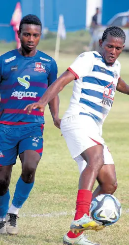  ?? LENNOX ALDRED PHOTO ?? Portmore United’s Stephen Barnett (right) shields the ball from the onrushing Dunbeholde­n defender Zackiya Wilks during their Jamaica Premier League encounter at Ferdie Neita Park in Portmore yesterday.