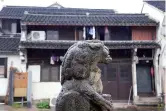  ??  ?? A stone lion at Xixing Ancient Town