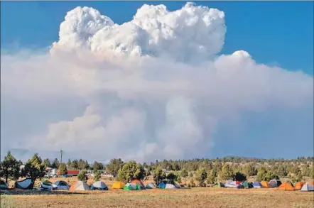  ?? Payton Bruni AFP/Getty Images ?? A SO-CALLED fire cloud billows into the sky near a fire camp in Bly in southern Oregon. The Bootleg fire absorbed a smaller blaze to become the largest wildfire burning in the country right now — so big that it has created its own lightning.