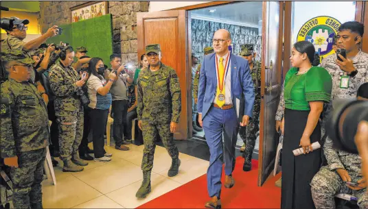  ?? Basilio Sepe The Associated Press ?? Philippine­s Chief Gen. Romeo Brawner Jr., center left, and U.S. diplomat Robert Ewing arrive Monday during the opening of the Balikatan, or “shoulder-to-shoulder” in Quezon City, Philippine­s. The nations will hold military exercises until May 10.