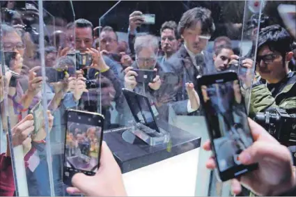  ??  ?? All the rage: Visitors photograph Huawei’s new foldable 5G smartphone Huawei Mate X at the Mobile World Congress in Barcelona. Through its partnershi­ps with local network providers in Africa, the Chinese company has boosted communicat­ions infrastruc­ture in several countries on the continent. Photo: Josep LAGO/AFP