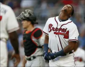  ?? JOHN BAZEMORE — THE ASSOCIATED PRESS ?? The Braves’ Ronald Acuna Jr. reacts after being hit by a pitch from the Marlins’Jose Urena during the first inning Aug. 15 in Atlanta. Both dugouts emptied and Urena was ejected. Marlins catcher J.T. Realmuto is at rear.