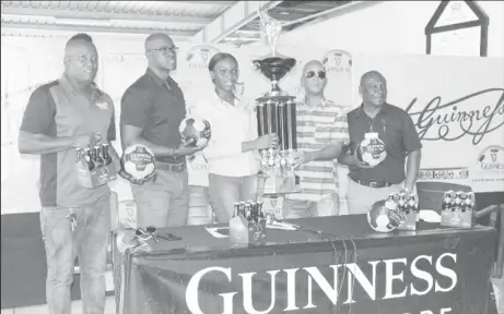 ??  ?? Tournament coordinato­r and Director of Three Peat Promotions Rawle Welch [centre] receives the championsh­ip trophy from Colours Representa­tive Creana Damon in the presence of Guinness Brand Executive Lee Baptiste [2 nd from left], Referees Coordinato­r Wayne Griffith [left] and Banks DIH Communicat­ions Manager Troy Peters.