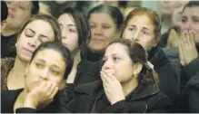  ??  ?? Mourners grieve during Friday’s funeral service for victims of the attack on the Coptic Church of Mar Mina in a Cairo suburb.