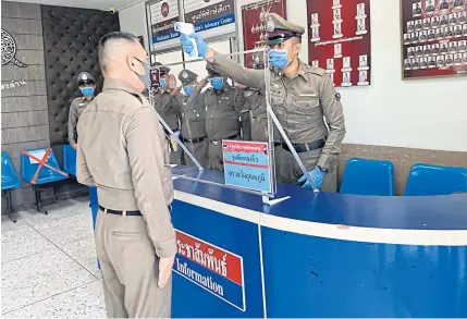  ?? PHOTO BY ATCHARIYA RUENGRATTA­NAPONG ?? National police chief Chakthip Chaijinda has his temperatur­e checked before entering Klong Dan police station where he asked about progress in the investigat­ion into alleged extortion committed by some of the station’s officers.