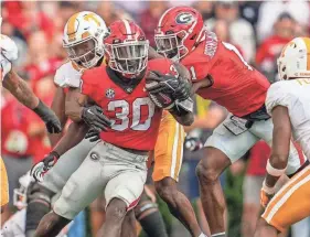  ?? DALE ZANINE/USA TODAY SPORTS ?? Georgia running back Daijun Edwards tries to break a tackle by Tennessee defensive back Brandon Turnage in the 2022 game.