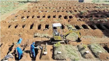  ??  ?? Des employés exhument des restes enterrés il y a trois ans au cimetière de Vila Formosa, à São Paulo, pour faire place aux besoins urgents en tombes.