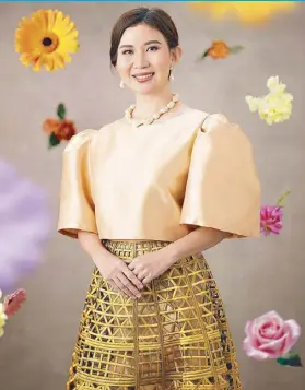  ?? ?? Rheumatolo­gist and medical professor Dr. Geraldine Zamora’s elegant Filipinian­a ensemble features a gold mestiza top, yellow laser-cut skirt, and baroque pearls.