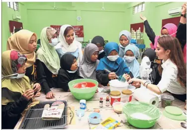  ??  ?? Starting young: Tengku Zatashah (standing fourth from left) and Anis (white blouse) going through the baking session with the children from Rumah Kebajikan Anak Yatim Alkhairiya­h.