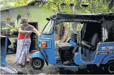  ?? ?? Lasanda Deepthi, 43, cleans her auto-rickshaw in Gonapola, on the outskirts of Colombo.