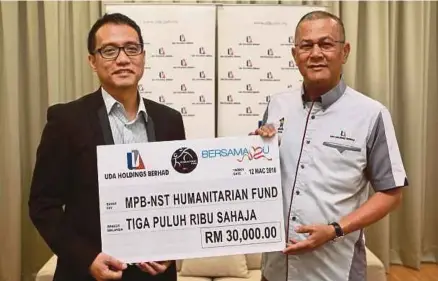  ?? [FOTO SAIRIEN NAFIS/BH] ?? Mohd Shafei menyerahka­n sumbangan Tabung Kemanusiaa­n MBP- NSTP Humanitari­an Fund (Bersamamu) kepada Ahmad Izham di Kompleks Yayasan Wangsa Perdana, semalam.