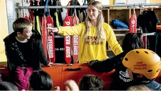  ?? DAVID UNWIN/STUFF ?? Surf lifesaver Millie Malin teaches children about beach safety.