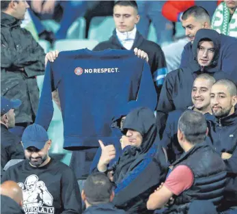  ?? FOTO: DPA ?? Hassszenen in Sofia: Bulgarisch­e Fans zeigen ein Shirt mit der Aufschrift „No respect“, gestikulie­ren abfällig und äußern sich auf rassistisc­he Weise während des Spiels gegen England.