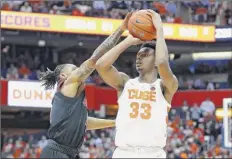  ?? rich Barnes / Getty images ?? Khwan fore, left, of Louisville alters the shot attempt of elijah Hughes of Syracuse. Hughes led the orange with 18 points.