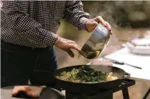  ?? BRETT CARLSEN/THE NEW YORK TIMES ?? Allan Benton, founder of Benton’s Smoky Mountain Country Hams, prepares potatoes with ramps in the Cherokee National Forest in Tennessee. Every spring, Benton heads to the woods to search for alliums and cook up a creekside feast.