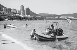  ?? ISAAC LAWRENCE/GETTY-AFP ?? Lifeguards in Hong Kong work Thursday after some COVID-19 restrictio­ns were relaxed. Among them included the reopening of beaches and pools.