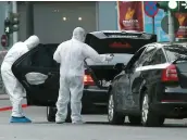  ??  ?? Des experts médico-légaux recherchai­ent hier des indices à la suite de l’explosion à l’arrière de la Mercedes noire.