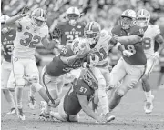  ?? Gerry Broome / Associated Press ?? Three North Carolina State defenders gang up on Clemson’s Ray-Ray McCloud in the first half Saturday. The Tigers hung on for a 38-31 victory.