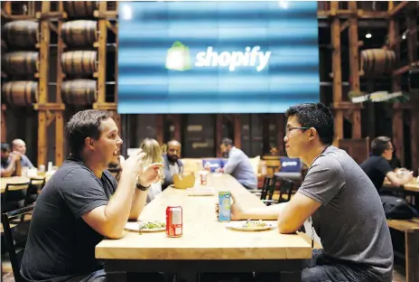 ?? COLE BURSTON/BLOOMBERG ?? Employees eat in a common area at the Shopify Inc. office in Waterloo, Ont. Shopify Plus, the company’s highest-tiered subscripti­on, is attracting migrations from other platforms.