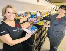  ?? LYLE ASPINALL ?? Leanne Courchesne of Cenovus, left, shows off 5,500 kilograms of donated food with Marie Blackburn, manager of the Veterans Food Bank, at the Bow loading dock in downtown Calgary on Tuesday.