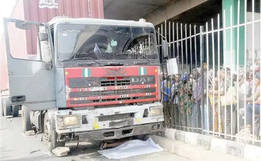  ?? NAN ?? Sympathise­rs catch glimpse of a woman crushed by an articulate­d vehicle at Molete in Ibadan on Wednesday.