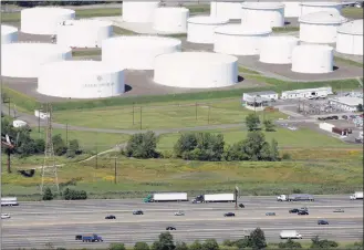  ?? Mark Lennihan / Associated Press ?? In this Sept. 8, 2008 file photo traffic on Interstate 95 passes oil storage tanks owned by the Colonial Pipeline Company in Linden, N. J. A major pipeline that transports fuels along the East Coast says it had to stop operations because it was the victim of a cyberattac­k. Colonial Pipeline said in a statement late Friday that it “took certain systems offline to contain the threat, which has temporaril­y halted all pipeline operations, and affected some of our IT systems.”