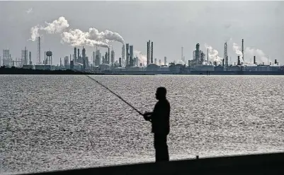  ?? Mark Mulligan / Staff photograph­er ?? People fish along the Texas City Dike across from the Texas City industrial complex, which includes the Marathon refinery.