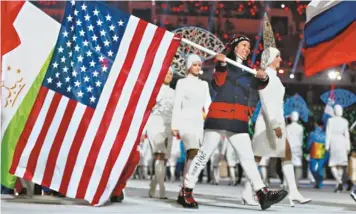  ?? JEFFREY SWINGER, USA TODAY SPORTS ?? Hockey player Julie Chu carries the flag for the USA in Sunday’s closing ceremony in Sochi.