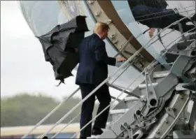  ?? ASSOCIATED PRESS ?? U.S. President Donald Trump folds his umbrella while boarding Air Force One before departing from Glasgow, Scotland, on his way to Helsinki, Finland, Sunday on the eve of his meeting with Russian President Vladimir Putin.