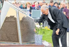  ??  ?? Msgr. Gerald LeBlanc, the local parish priest, was among those laying flowers as part of the monument unveiling ceremony in West Pubnico in August.