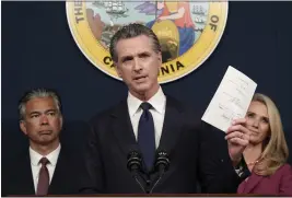  ?? RICH PEDRONCELL­I — THE ASSOCIATED PRESS FILE ?? Gov. Gavin Newsom displays a bill he signed that shields abortion providers and volunteers in California from civil judgements from out-of-state courts during a news conference in Sacramento on June 24.