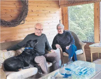  ?? KEITH BRANSCOMBE ?? NOW: David Acomba, sits with his wife, Sharon Keogh, and Chester in their “car porch” — a convertibl­e carport they use as a living and dining area in warmer months. We live in and use every part of the house daily,” Acomba said.