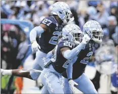  ?? GERRY BROOME/AP ?? NORTH CAROLINA DEFENSIVE BACK Giovanni Biggers (27), defensive back Tony Grimes (20) and defensive back Storm Duck react after a pass play broken up by Duck during the second half of a game against Wake Forest in Chapel Hill, N.C., Saturday.