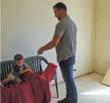  ?? ?? Alain Melchor, at right, hands his son Damian, 1, at left, a screwdrive­r to play with as he sits in one of the three bedrooms on Oct. 27 in Mesa. The search for a home began in May 2021.